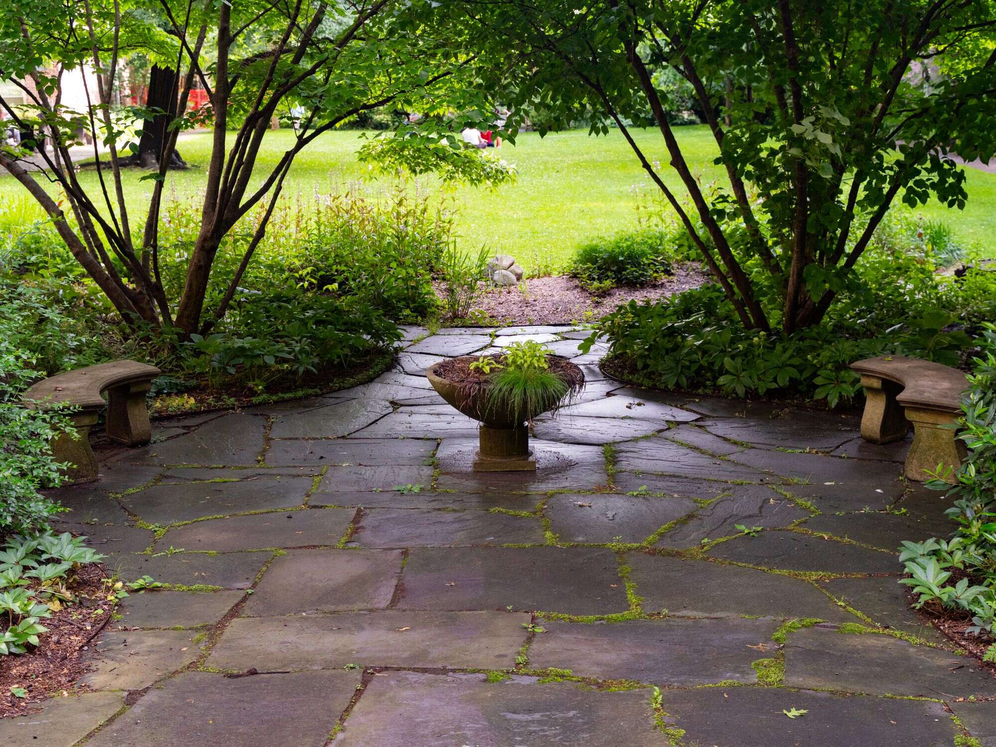 Finished stone patio surrounded by a garden