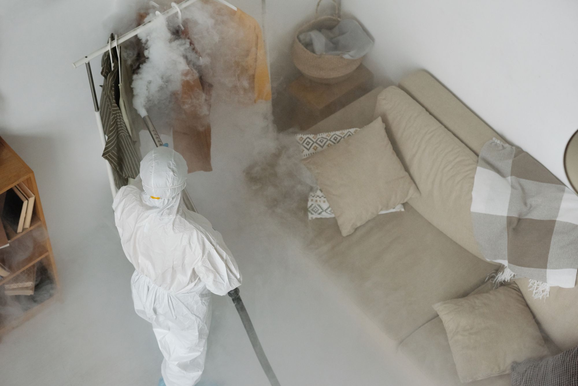 Technician in protective gear inspecting an interior space